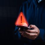 Smartphone in a dark setting symbolizing online dating risks and safety concerns for LGBTQ+ individuals